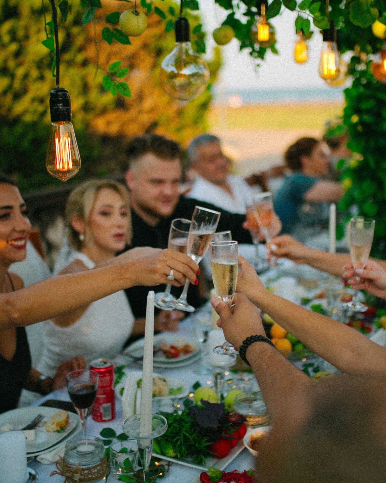 A champagne toast at a candlelit table at golden hour on the Riviera