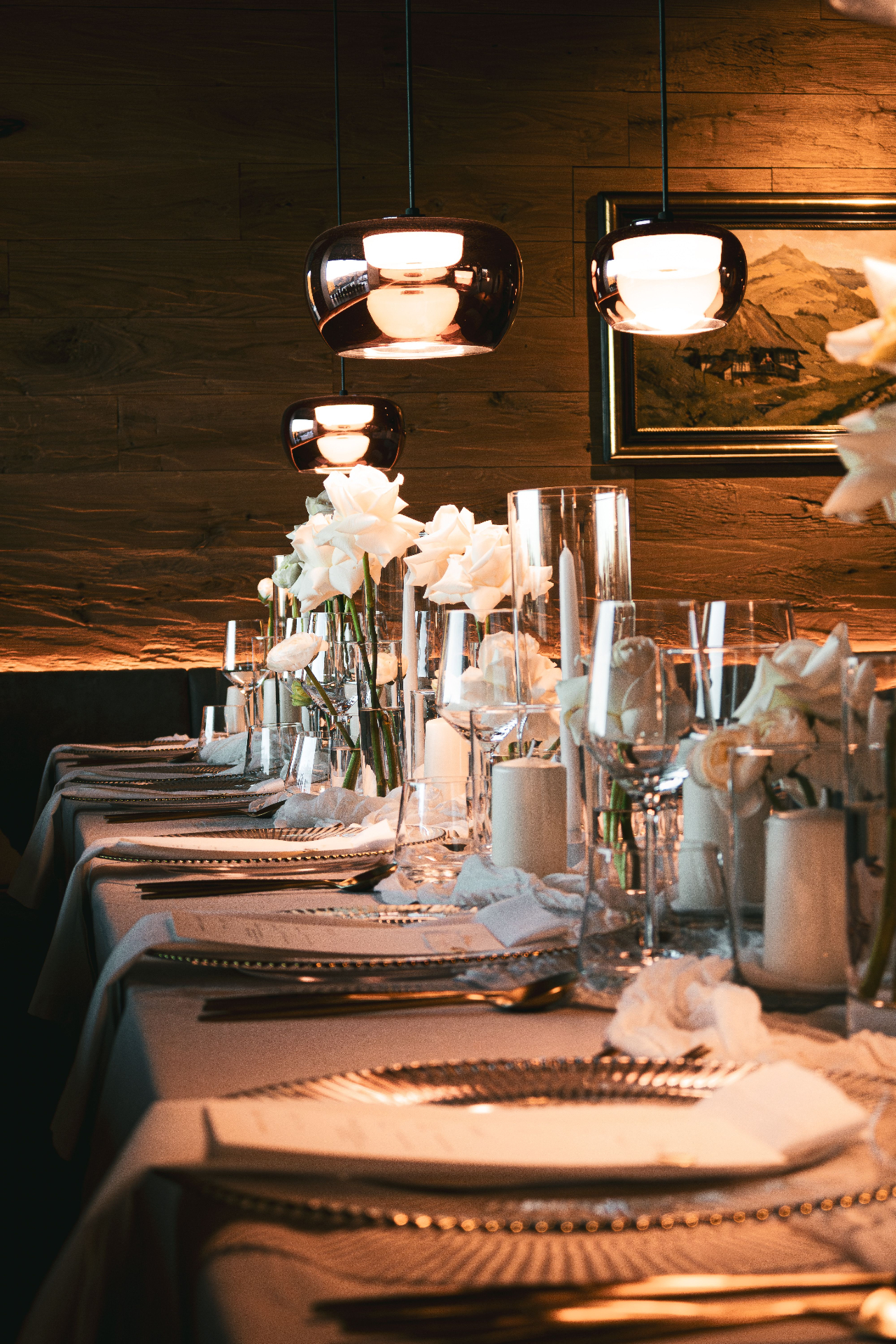 A candlelit tablescape with white roses and taper candles